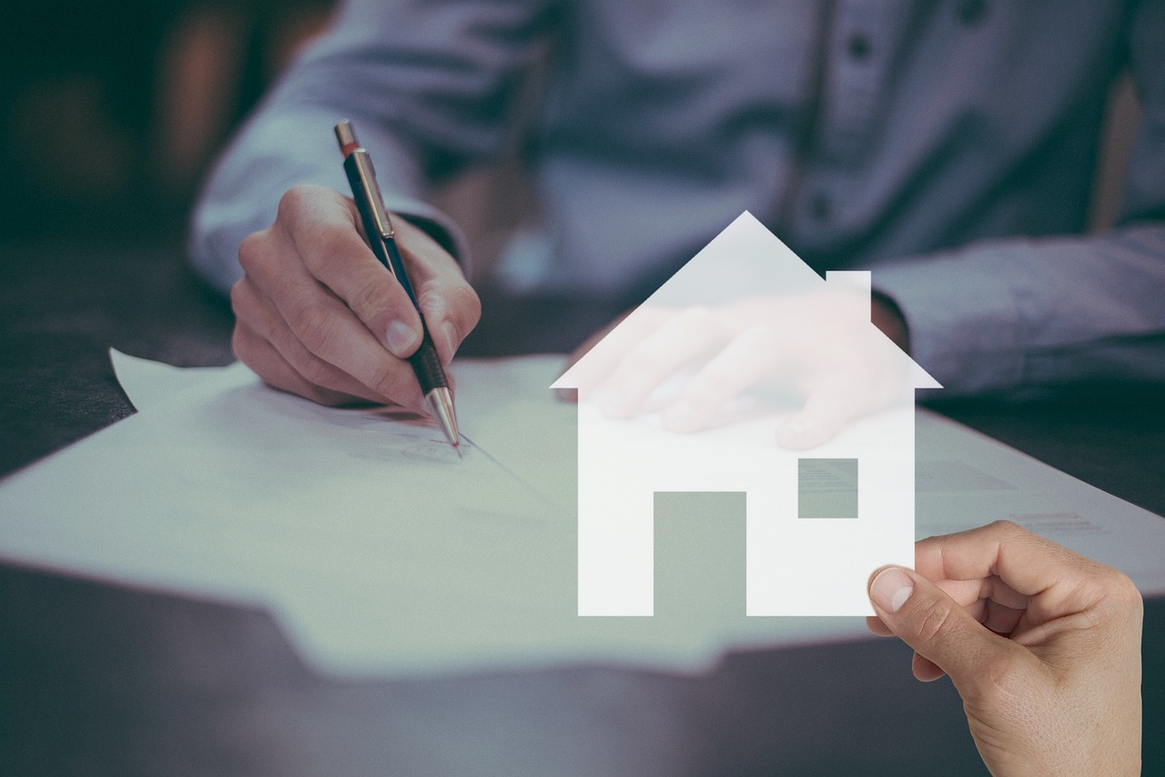 A person reviewing and signing loan documents at a desk.