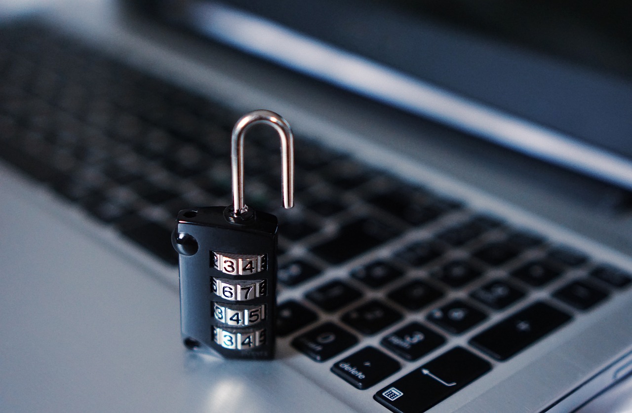 A padlock resting on a laptop keyboard to suggest locked personal data.