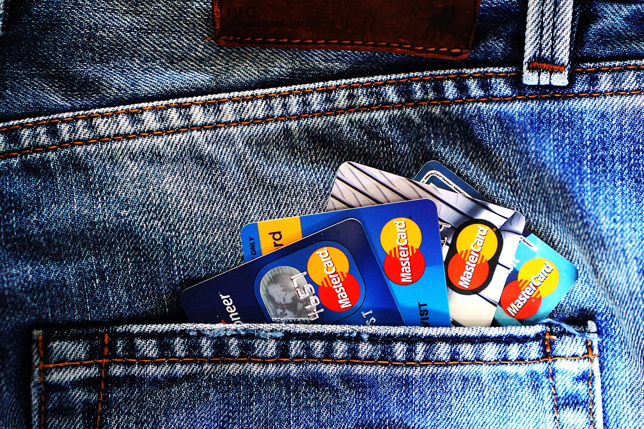 A debit card held over a card reader at a store.