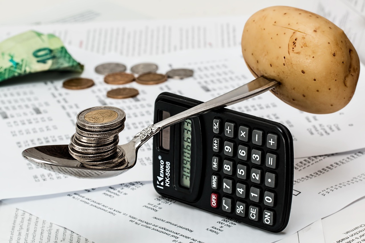 A calculator and a stack of monthly bills on a kitchen table.
