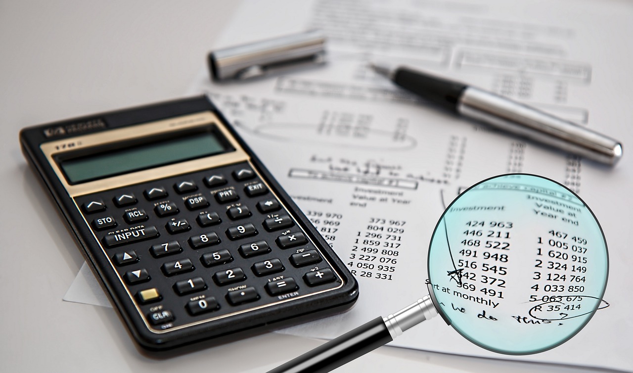 A person reviewing printed financial documents with a highlighter.