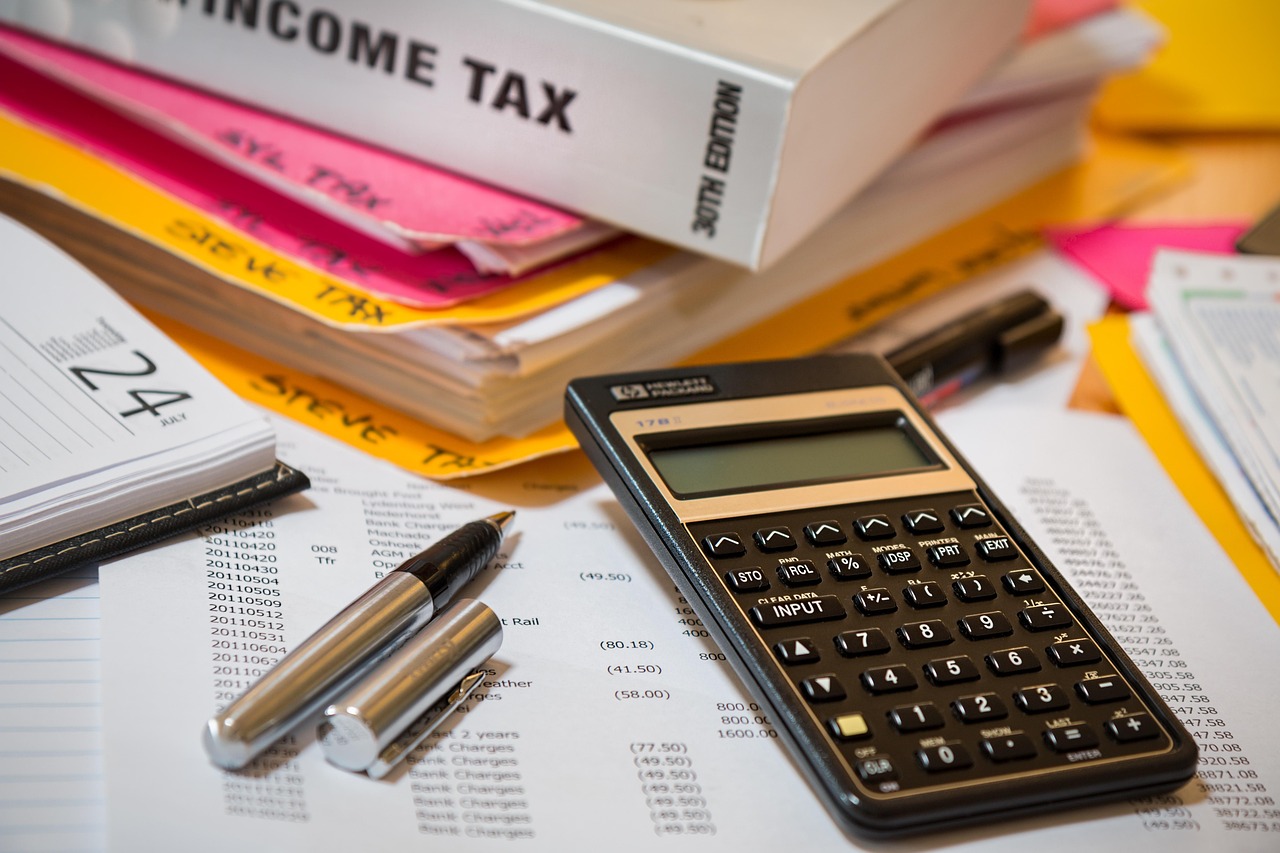An open notebook with a handwritten list of debts and payments.